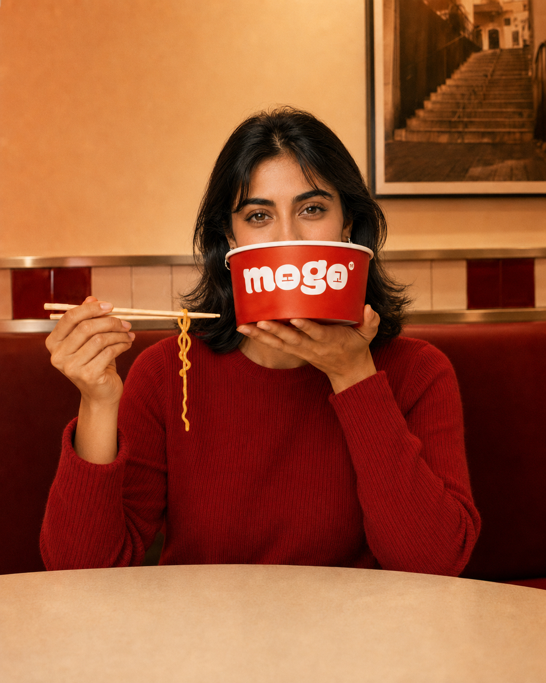 Character A playfully holding a MOGO bowl in the restaurant