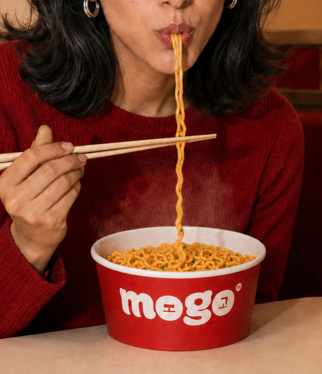 Character A eating noodles from a MOGO bowl