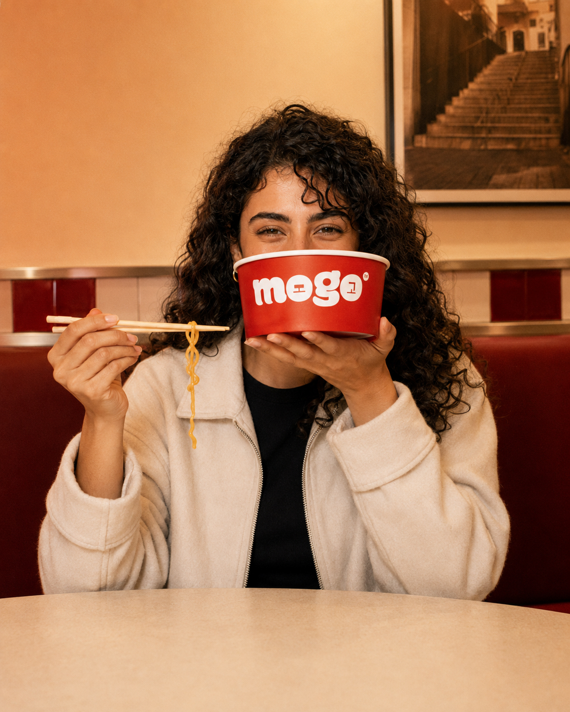 Character B playfully holding a MOGO bowl in the restaurant